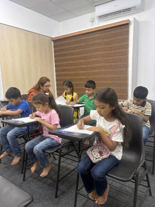 Children seated at desks completing classwork in a ScoreMax classroom.